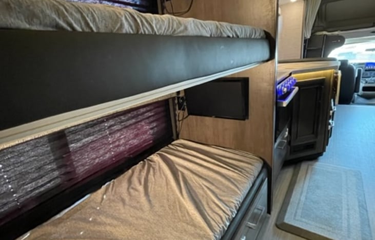 Bunk beds with a tv and DVD player in each bunk.