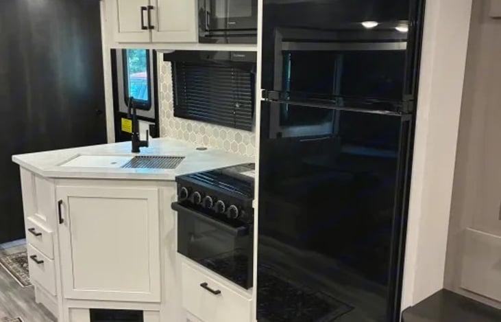 The fully equipped kitchen makes cooking on the road simple and enjoyable. It includes a stovetop, oven, microwave, and refrigerator, plus ample counter space for preparing meals.