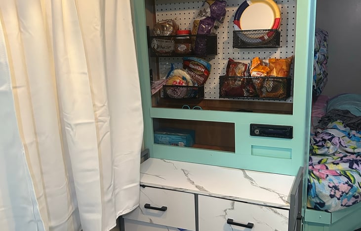 Peg board storage for easy access to snacks with 8 drawer dresser below.