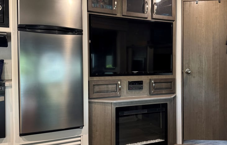 50 inch tv, stereo allows you to play music inside and outside! Fireplace that can be used for the cool lights or as a heater. RV fridge was replaced with dorm size for extra grocery space!