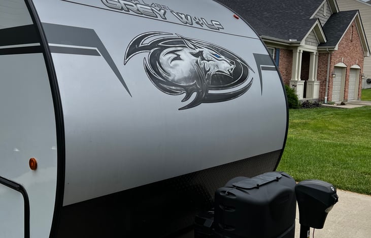 Right front of the RV. Two propane tanks and a power jack.