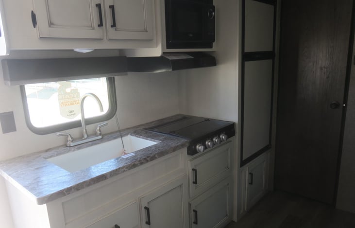 Kitchen - Large single basin sink, window, full sized fridge and freezer as well as the 3 burner stove top.