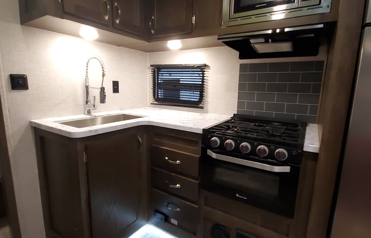 Kitchen with microwave, gas range and oven for easy cooking and meal prep. Oven can accommodate one 9x13 dish.