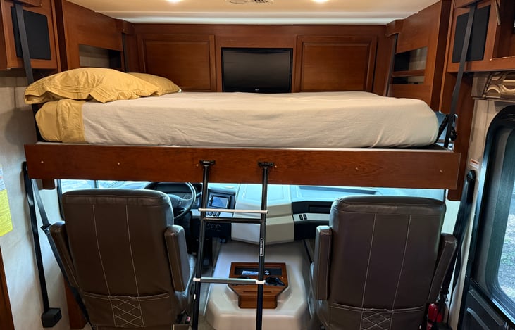 Drop down full bed above the driver/passenger seat is very comfortable with its own private TV!