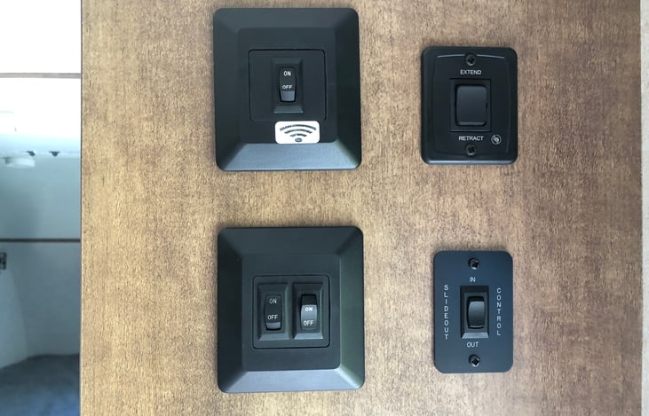 Control panel near front door. Top right controls awning and bottom right controls slideout.
Bottom left is lighting. Lighting is also controlled inside via ceiling "buttons", just press to operate.