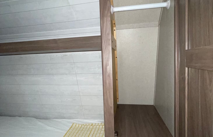 Extra storage space and clothing rack by the bed.