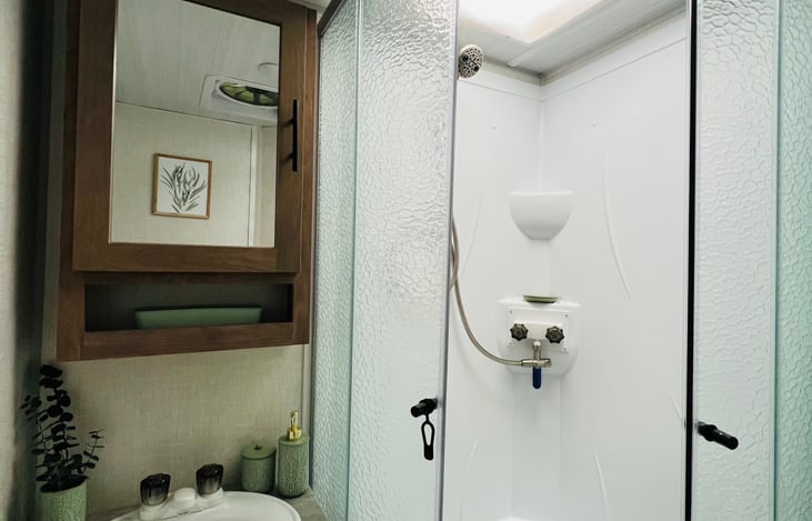 Spacious shower with expanded head room and removeable showerhead. This camper boasts a 6 gallon hot water tank keeps the shower long and hot!