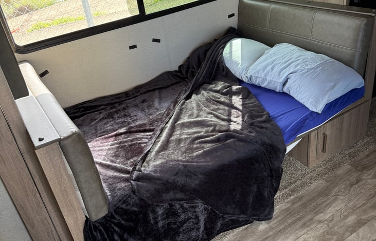 Shown here  is the table area converted  to a large bed, measuring 77" long by 45" wide.  It is a very comfortable area that can fit adults as well as children.  This measures 6'5" long .