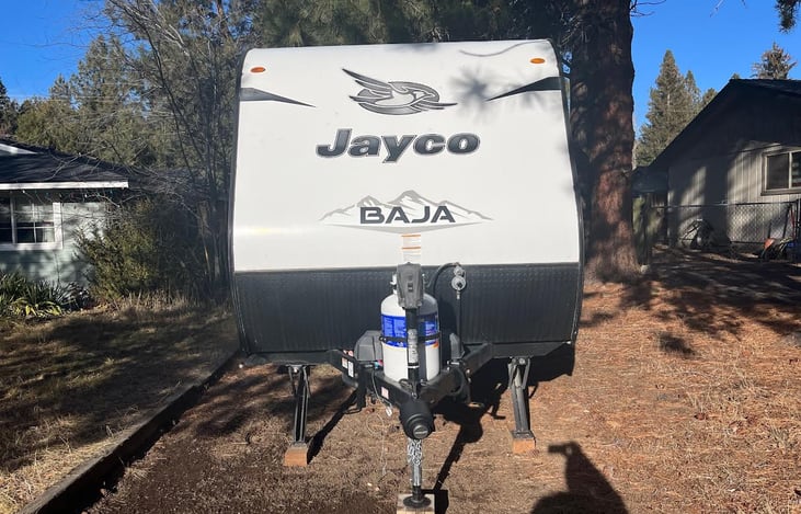 Front of RV with propane tank, power jack, and corner stabilizers