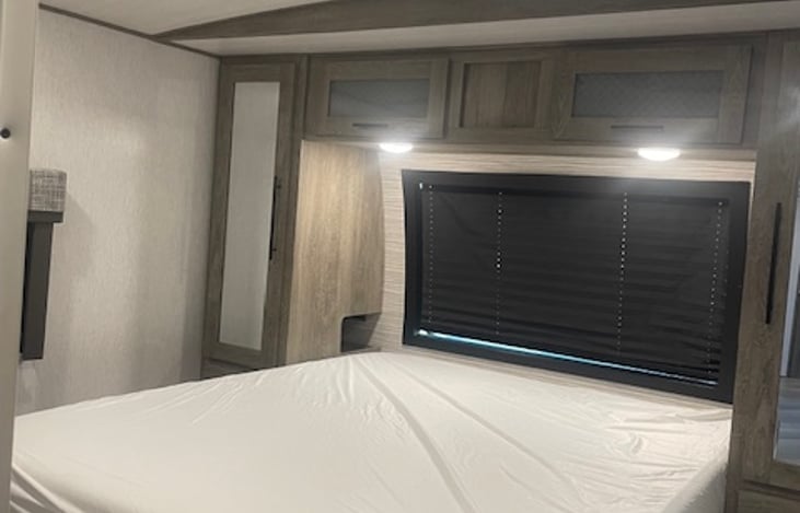 Master with queen bed and hanging storage cabinets.