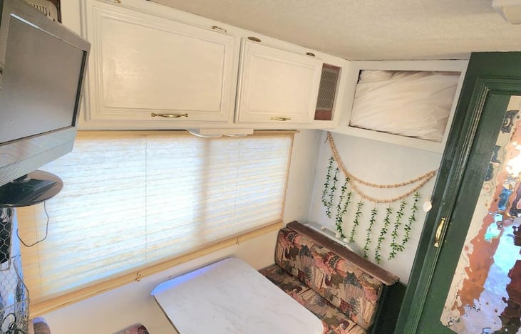 Back table transforms into bed. Tv is adjustable. Cabinets space as tons of storage. extra pillows provided as well.