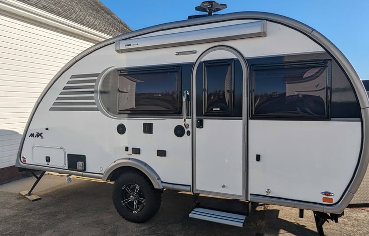 Side view:  Showing exterior entertainment, awning, rear storage, external propane connection for grill and entrance.