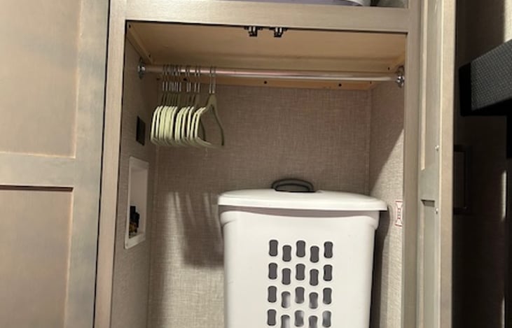 Bedroom closet includes hangers, hamper and ample storage
