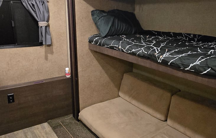 bunkhouse with top bunk and fold down cushion couch into bed for 2 people.