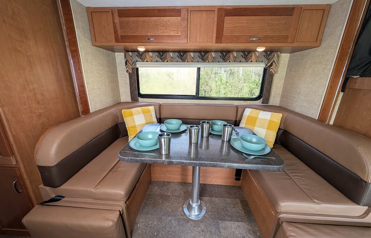 Large cozy dinette with overhead storage that converts to a cozy Full bed.