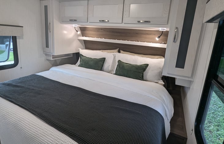 Memory foam King size bed. Hypoallergenic Down Alternative Bedding, High Quality Cotton Linens. Underbed and overhead storage, including hanging space.  Multiple charging ports.