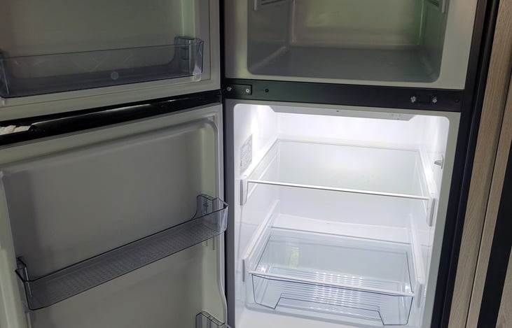 Fridge runs off of electricity or the propane tanks if electrical is not available.