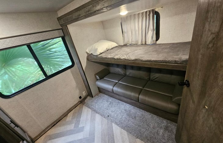 Bunkroom with top bunk and sleeper sofa.