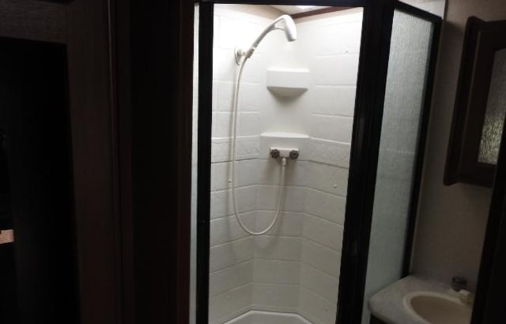 Removable-remote shower head, glass shower door, sunroof over shower.