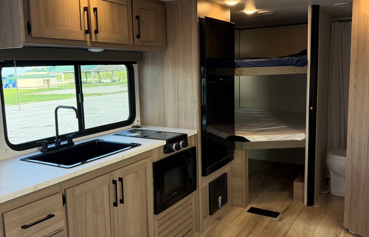 Fully equipped galley kitchen with sleek countertops, modern appliances, and convenient access to the private bunkhouse area.