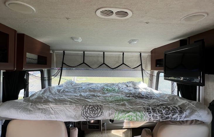 Drop down bed with inflatable mattress. TV can be in bedroom, and curtains / windshield visor closes for privacy.