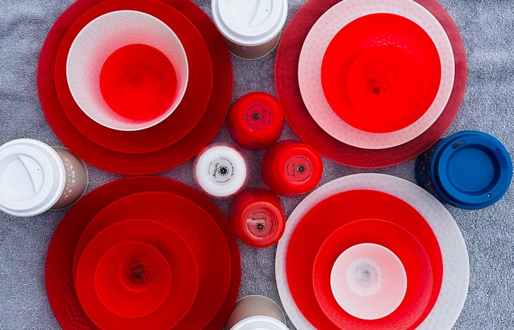 Place settings for four people include plates, bowls, cups and coffee cups with lids (design may vary from photo). Not pictured but also included- forks, spoons, and butter knives for four.