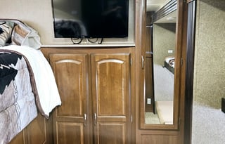 Large RV with outdoor kitchen, fireplace, and TVs