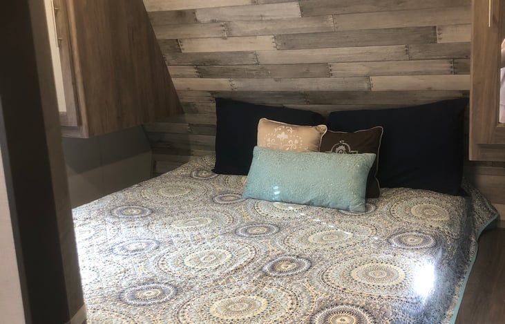 Master Bedroom with walk around Queen size bed with storage underneath and wardrobes and bedside stands on both sides.