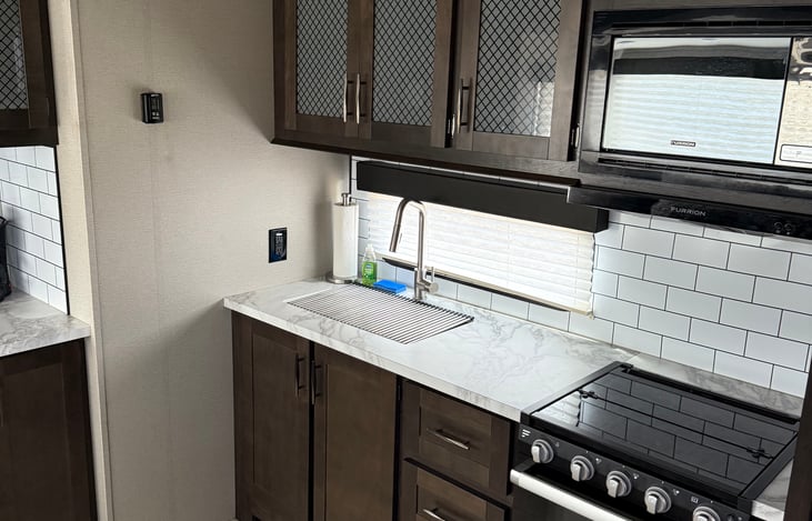 Full kitchen. 3 burner gas range with stove below.
