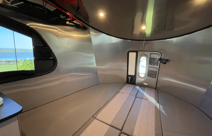When it is time for sleep, the entire seating area quickly converts into a massive, king-size bed equivalent space, stretching across the full width of the trailer to deliver premium, expansive sleep.