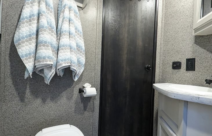 Bathroom with towels and vent fan.