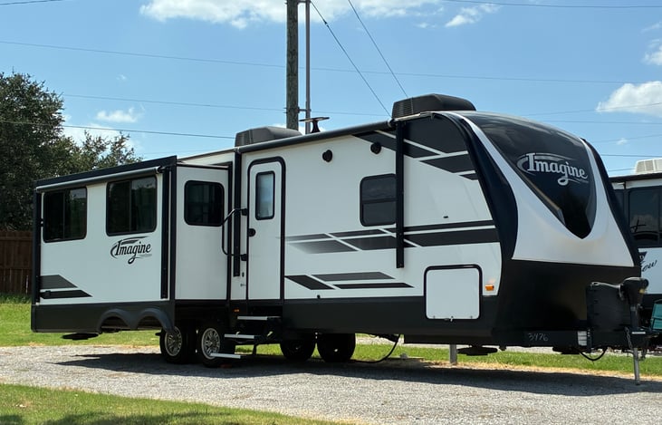 2019 Grand Design imagine with a queen bed, three seat/both end reclining movie theatre couch, and movie theater love seat with dual recliners and charging ports. 2 TV’s and stereo.