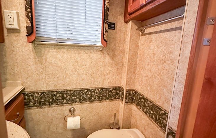 Spacious bathroom has a door to provide privacy, and extraction fan to remove the evidence.