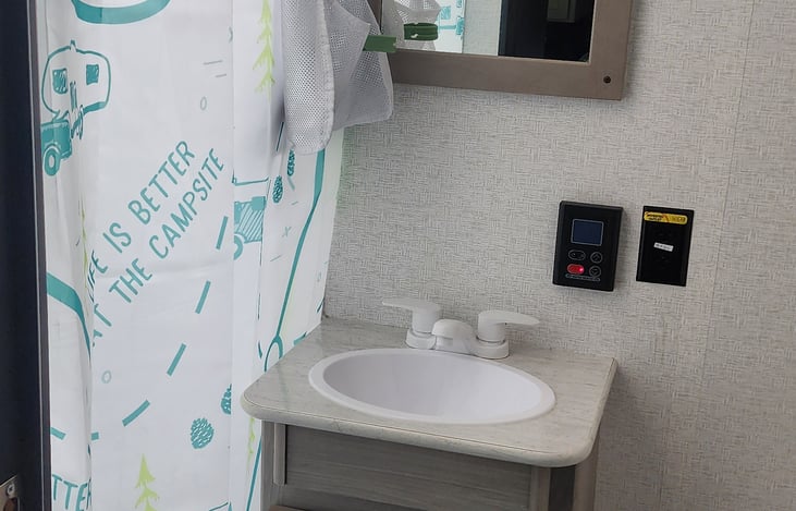 Shampoo, conditioner and body wash are in the bag hanging inside the shower. Outside bag is hand soap, lotion and magnetic towel holders.