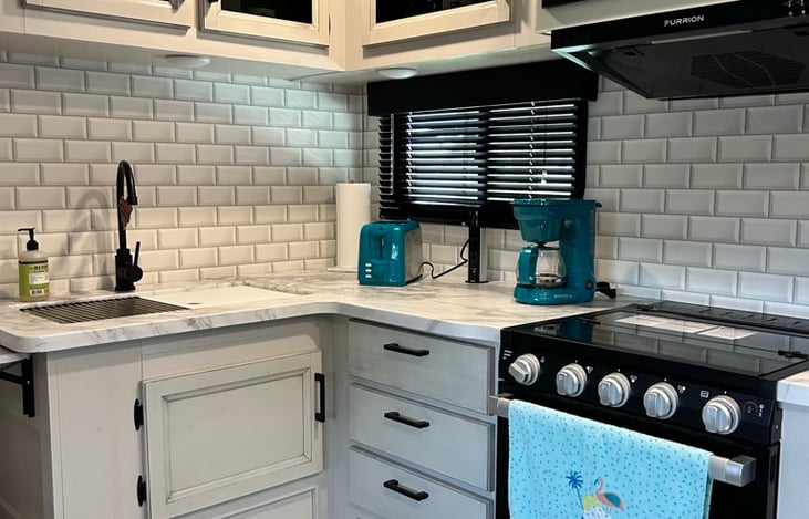 A complete kitchen with all the essentials including dishes, cookware, a toaster, small air fryer and coffee maker.