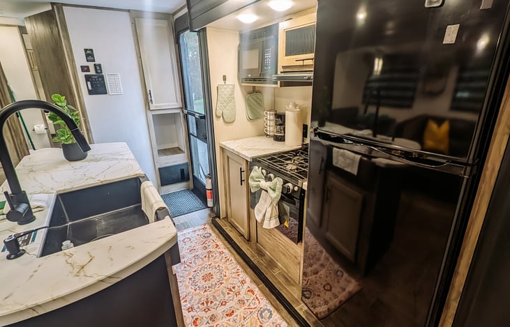 Another view of the kitchen, nice size refrigerator.