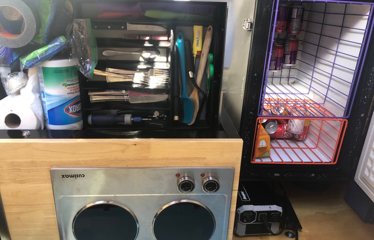Strange view of stove and xl fridge / freezer. Kitchenware included with cast iron pots / pans / Dutch over.  Cook on the infrared inside, or full sized 2 burner propane stove with grill outside.