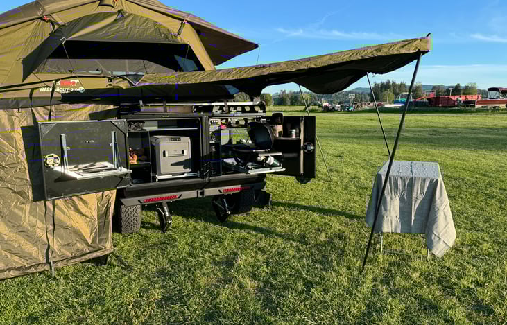 Rear area with fold out shelves for prep work.  Rooftop table box holds collapsable table witch is height adjustable for different uses.  Domestic 55lMI Ice Making refrigerator on slide out.