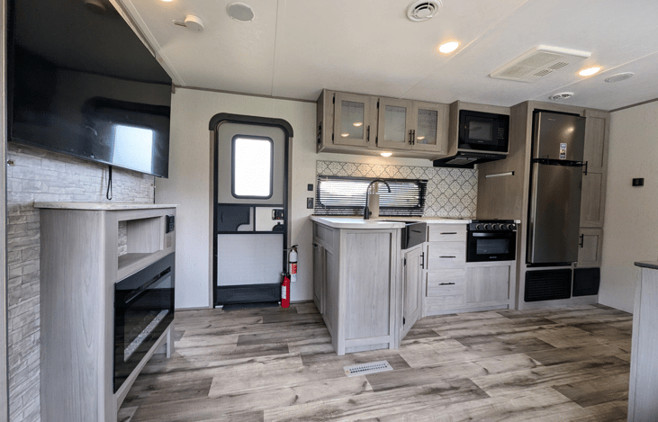 Bright, spacious and modern interior with large, well-equipped kitchen. Features two large slide-outs, ample storage throughout, electric fireplace, large TV, private bedroom, rear bunkhouse and more.