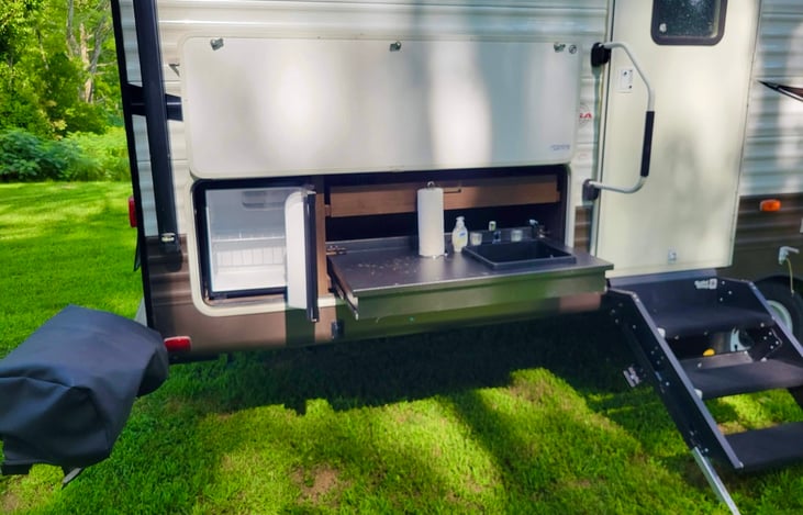 This outdoor kitchen is perfect for your glamping needs! Brand new grill with detachable flattop griddle, mini fridge, sink and storage drawer.