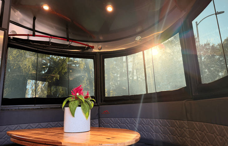 The panoramic front dinette offers a sunlit dining space that easily converts into a cozy bed for a child when needed. Mirroring larger luxury Airstream models, the iconic riveted aluminum interior.