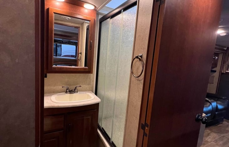 Bath has full shower with sliding glass door