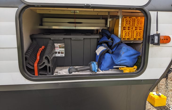Passenger side storage with all of the jack blocks, folding table, and tools.