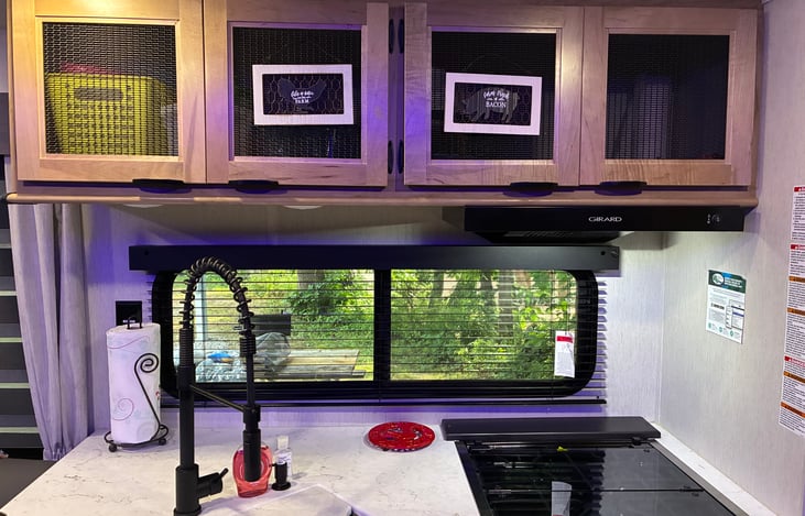 Nice open kitchen with convection oven/microwave. Large pantry stocked with some of the camping essentials.  Overhead cabinets are open for storing your supplies