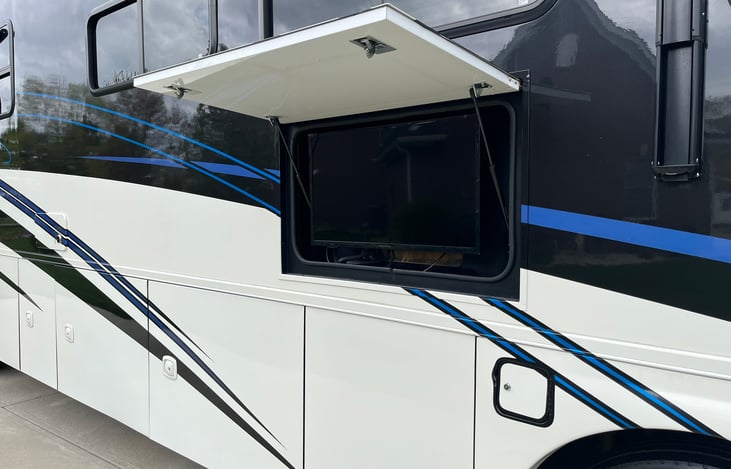 Outdoor TV, camper comes with rug, camp chairs, outdoor grill, board games.