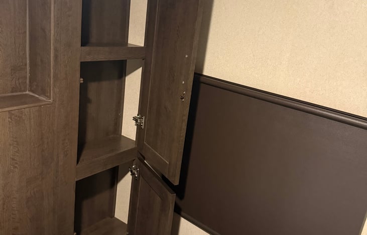 Four shelves with doors for storage in master bedroom.