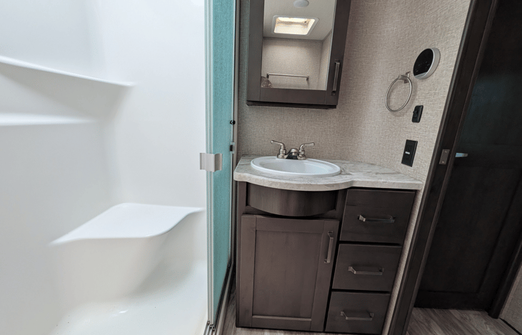 Spacious bathroom with full walk-in shower and skylight for natural light.