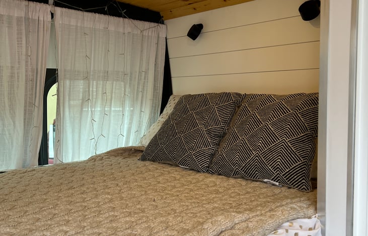 View of the bed with two reading lights and privacy curtains.