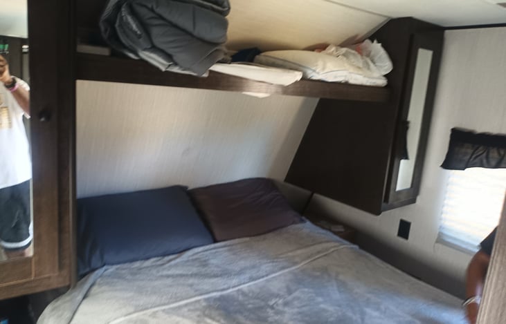 Master bedroom with queen bed.  Storage closets on each side and shelf at top