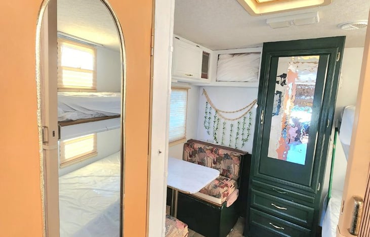 This is looking into the backroom, which can be closed off to the front. Has a tv and 3 beds. The table converts into a twin bed. The bunk is two twin xl beds. Storage under all beds and closet.